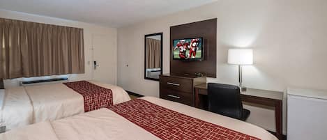 Een hotelkamer met twee bedden, een bureau, een stoel, een televisie en een lamp.