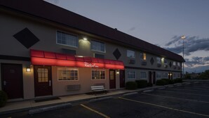 A Red Roof Inn with a red awning, a parking lot, and a clear sky. - Red Roof Inn Dayton - Huber Heights (Dayton)