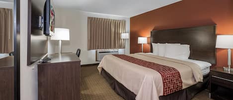 Een hotelkamer met een bed, nachtkastjes, een bureau, een stoel, een televisie en een raam met gordijnen.