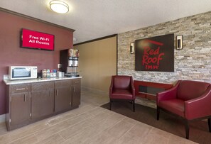 A Red Roof Inn reception area with a coffee machine, microwave, and a sign indicating free Wi-Fi in all rooms. - Red Roof Inn Dayton - Huber Heights (Dayton)
