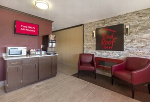 Zona de recepción de Red Roof Inn con máquina de café, microondas y señalización que indica Wi-Fi gratuito en todas las habitaciones.
