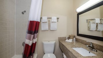 Un baño con inodoro, lavamanos, espejo, toallero y cortina de ducha.
