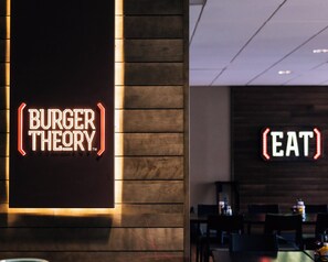 A restaurant interior with a neon sign reading "BURGER THEORY" and another sign saying "EAT". - Holiday Inn Grand Rapids Downtown by IHG (Grand Rapids)