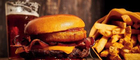 A burger with bacon, cheese, and a side of fries.
