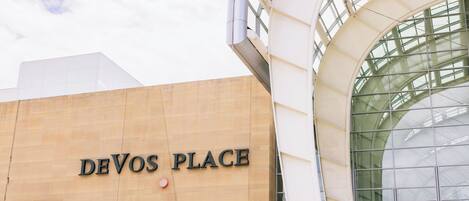 Un edificio con un cartel que dice "DEVOS PLACE" y una amplia estructura de ventanas de vidrio.