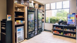 Un espace de libre-service proposant des boissons, avec des distributeurs réfrigérés et des distributeurs automatiques de collations.