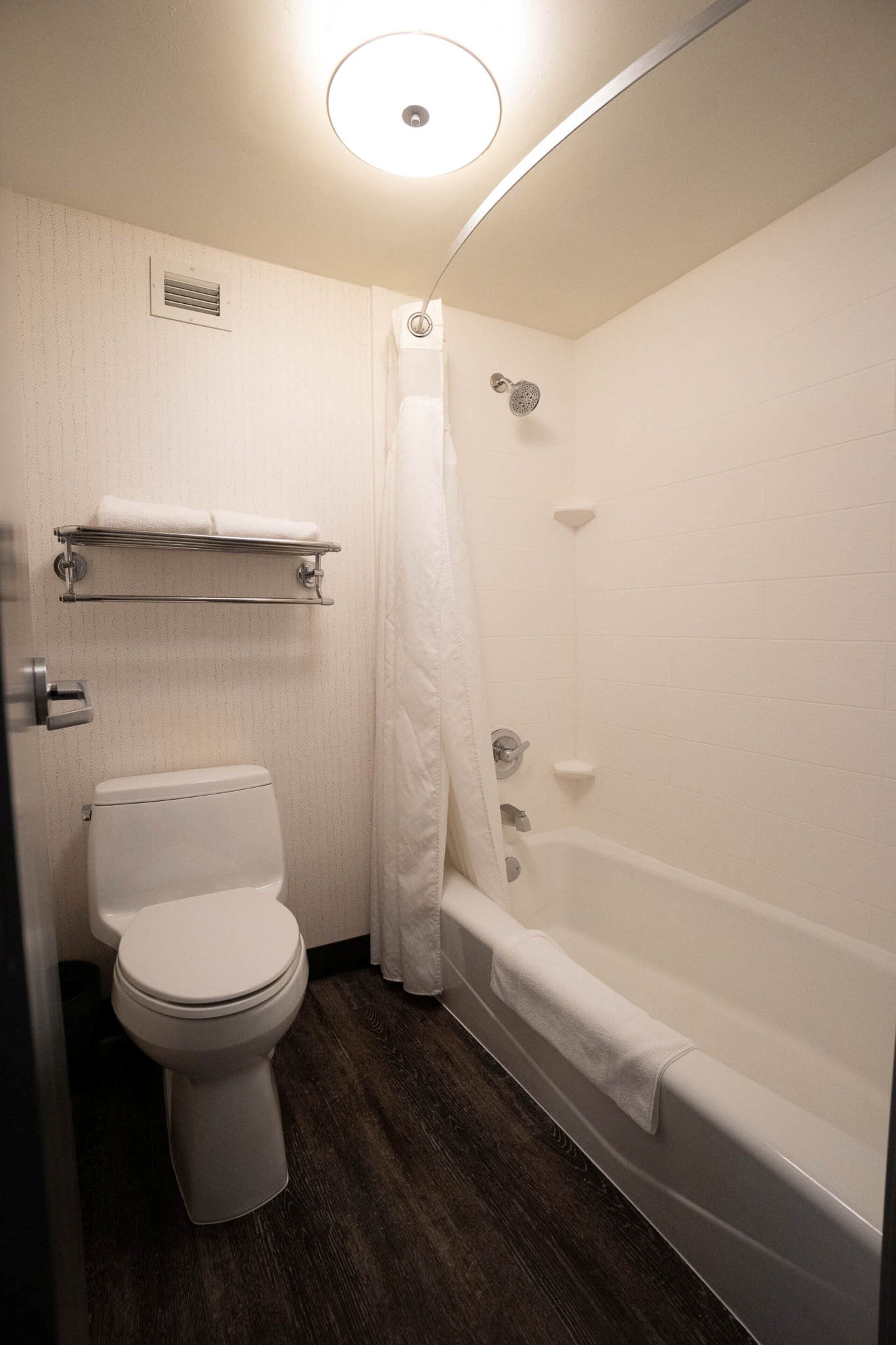 Un baño con inodoro, ducha y bañera.