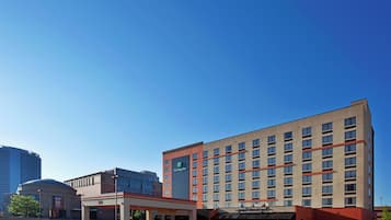 A multi-story hotel with a flat facade, a Holiday Inn sign, and a parking lot in front.