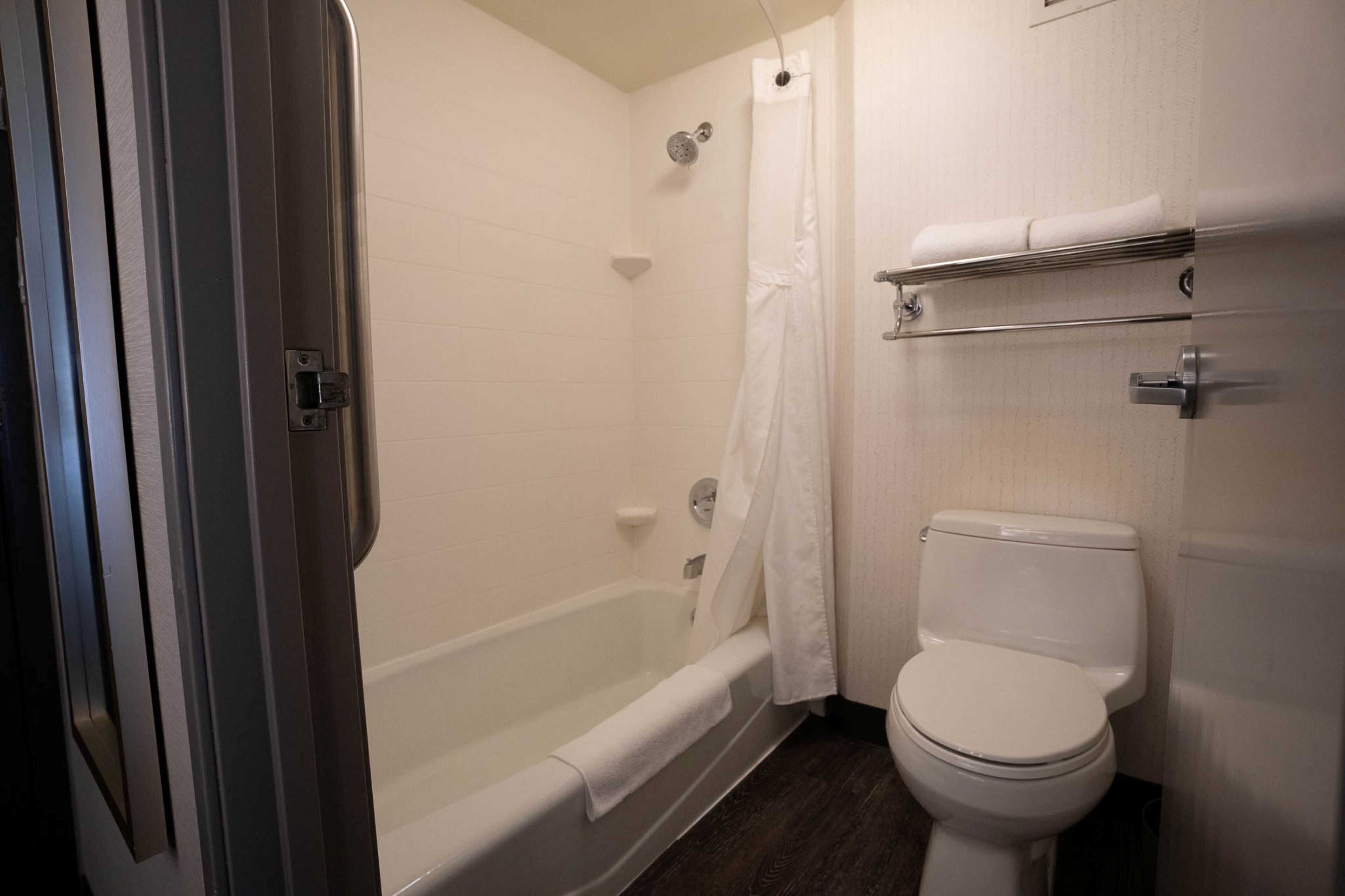 A bathroom with a bathtub, toilet, and a shower curtain.