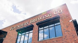 Un bâtiment en briques doté de grandes fenêtres et portant l’enseigne « Founders Brewing Co. »