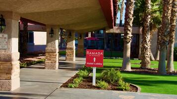 A hotel lobby with a sign indicating the direction to the Ramada Hotel Lobby.
