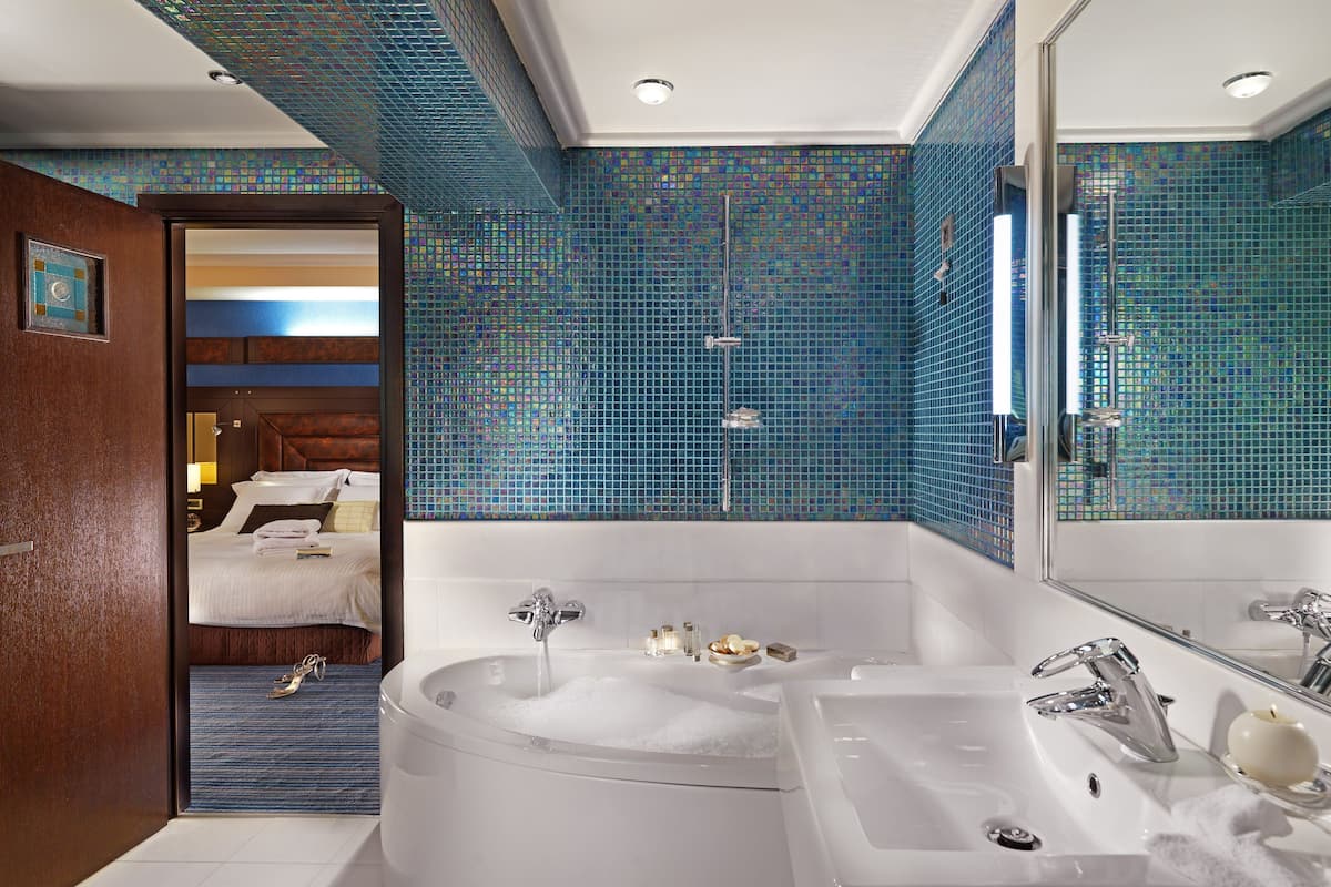 A modern bathroom with a large bathtub, a separate sink, and a shower.