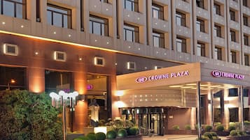 A modern hotel with a prominent entrance, illuminated signage, and a well-maintained exterior.