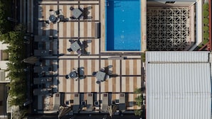 An aerial view of a rooftop pool area with multiple lounge chairs and a swimming pool. - Crowne Plaza Athens City Centre by IHG (Athens)
