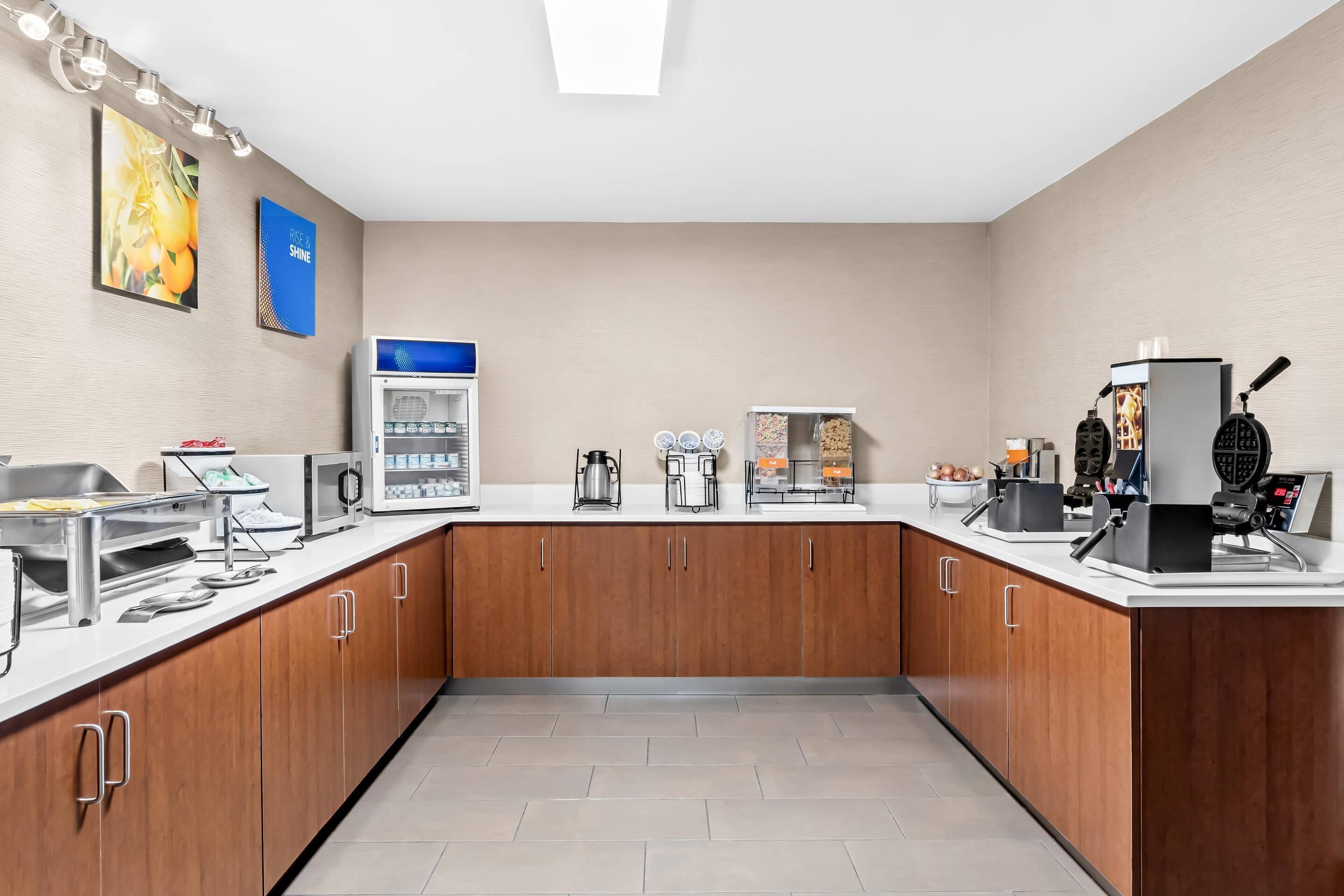 Una cocina moderna con microondas, cafetera y mostrador de alimentos.