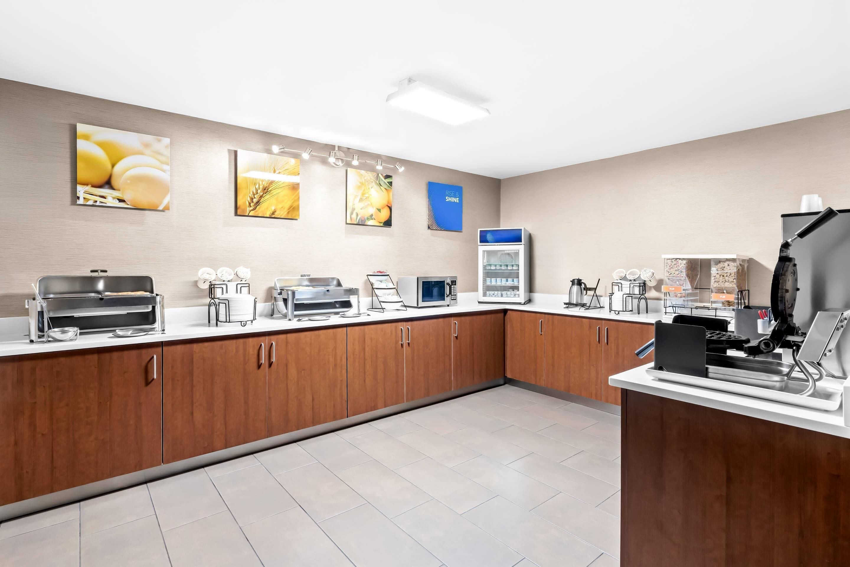 A modern kitchen with wooden cabinets, a microwave, a coffee machine, and a refrigerator.