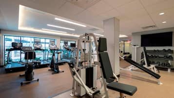 A gym with treadmills, elliptical machines, and weightlifting equipment.