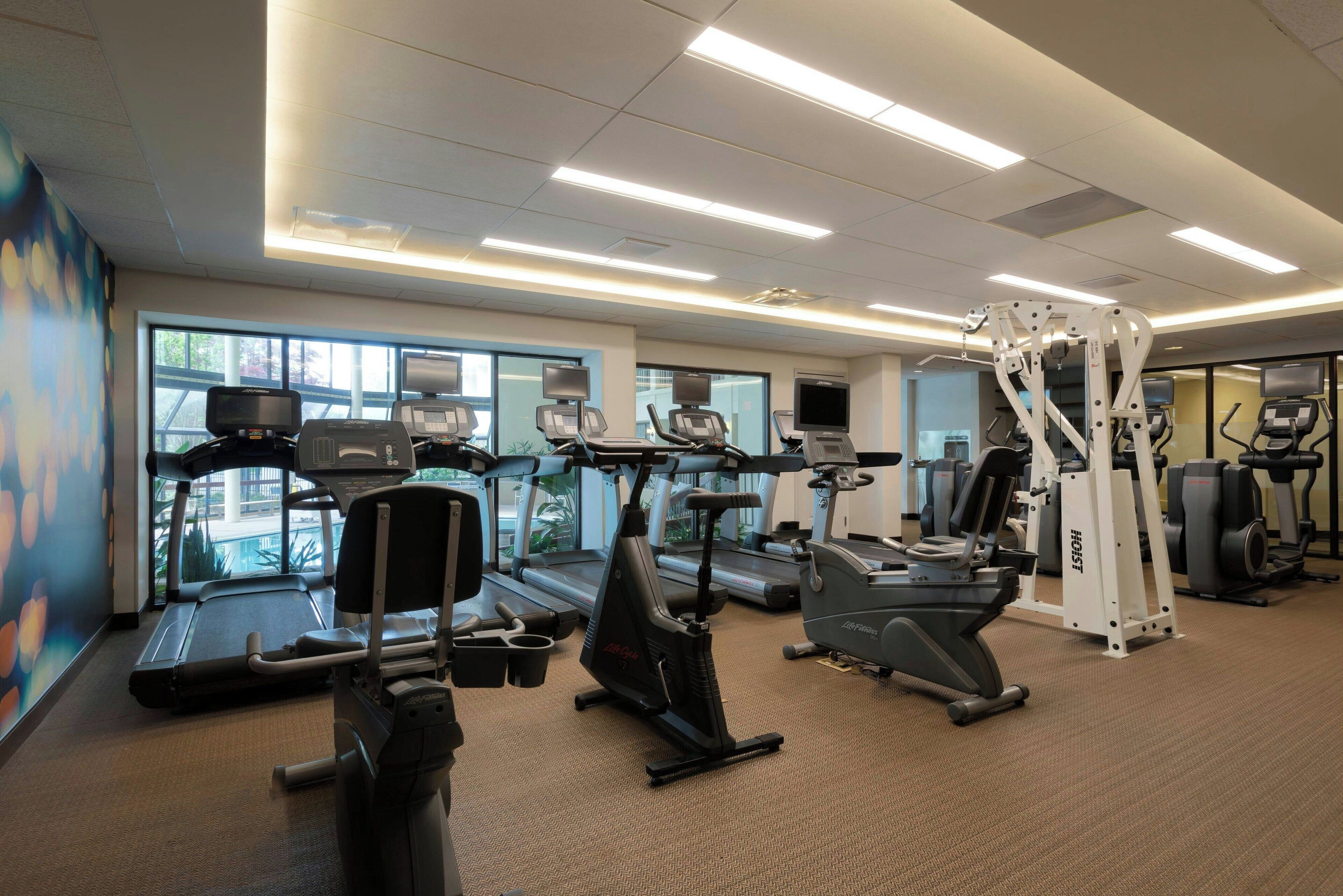 A gym with treadmills, elliptical machines, and weight equipment.
