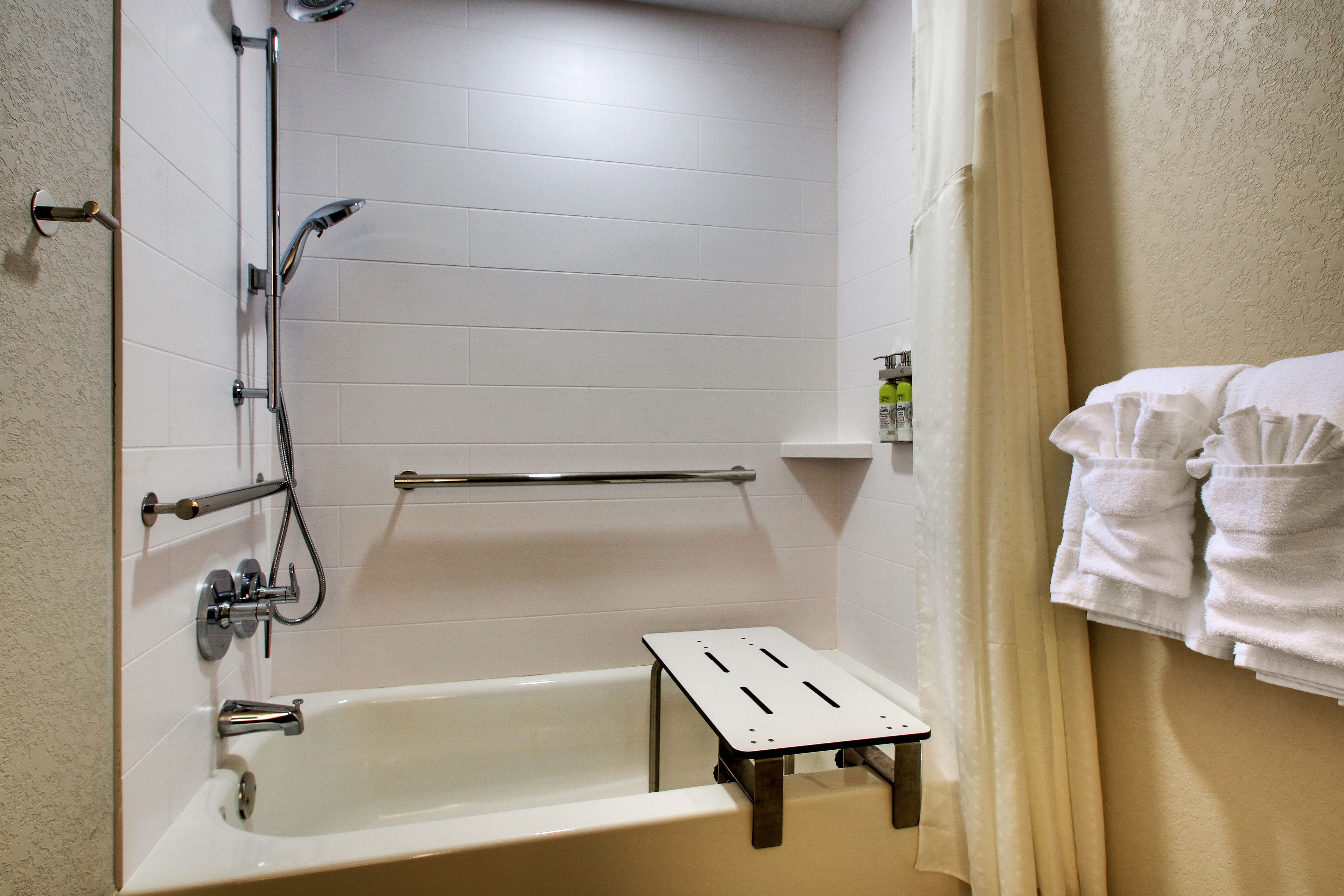 A bathroom with a bathtub, a shower, and a towel rack.