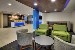 Vestíbulo de hotel con mostrador de recepción, zona de estar y ascensores.