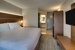 A hotel room with a large bed, a wooden headboard, a flat-screen TV, a wooden wardrobe, and a bathroom visible through an open door. - Holiday Inn Express Atlantic City W Pleasantville by IHG (Pleasantville)