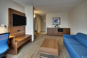 A hotel room with a flat-screen TV, a sofa, a coffee table, a desk, and a kitchenette. - Holiday Inn Express Atlantic City W Pleasantville by IHG (Pleasantville)