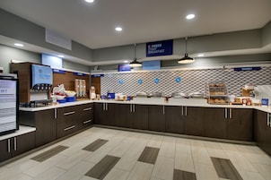 Un moderno comedor con estación de autoservicio, una sección de panadería y una presentación de frutas.