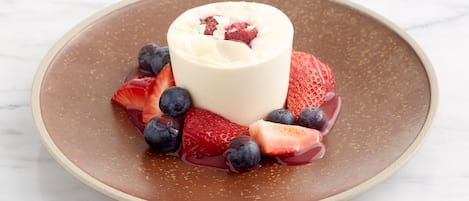 Ein Dessert auf einem Teller mit Erdbeeren und Blaubeeren.