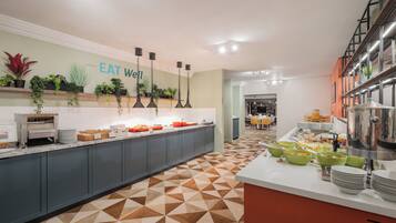 Une cuisine moderne avec un sol à motifs géométriques, un buffet et un panneau indiquant : « MANGEZ BIEN ».