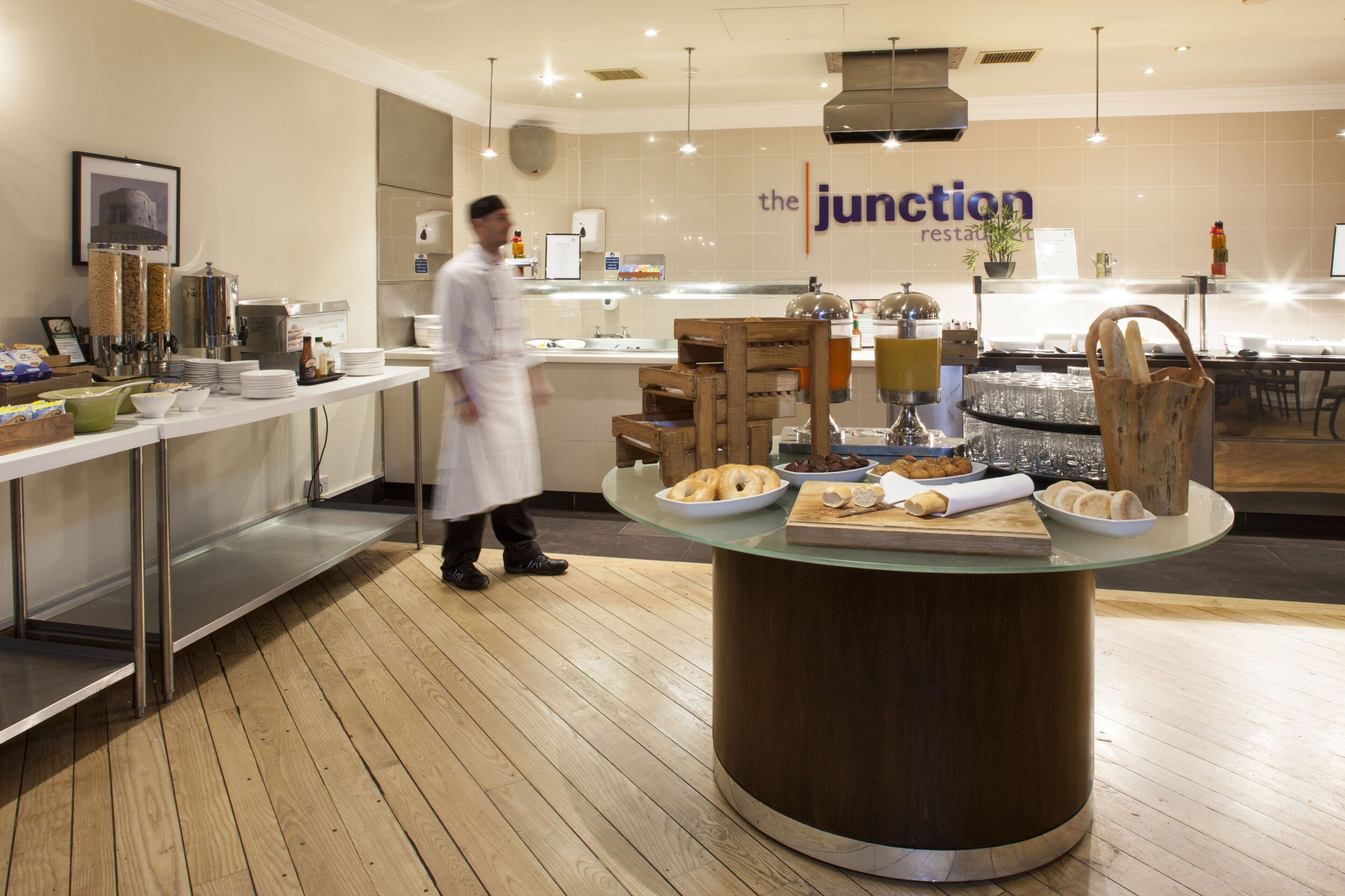 Un área de cocina moderna con un bufé, que incluye diferentes opciones de comida y un letrero que dice 'the junction restaurant'.
