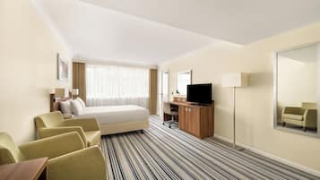 Minibar, escritorio, cortinas blackout y tabla de planchar con plancha