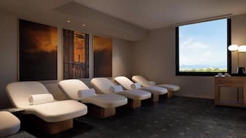 Relax in a serene space with reclining chairs, a large window, and abstract art.