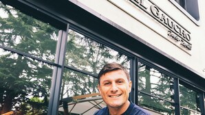 A man standing in front of a building with large windows and a sign that reads "Hotel del Gaud". - Sheraton Milan San Siro (Milan)