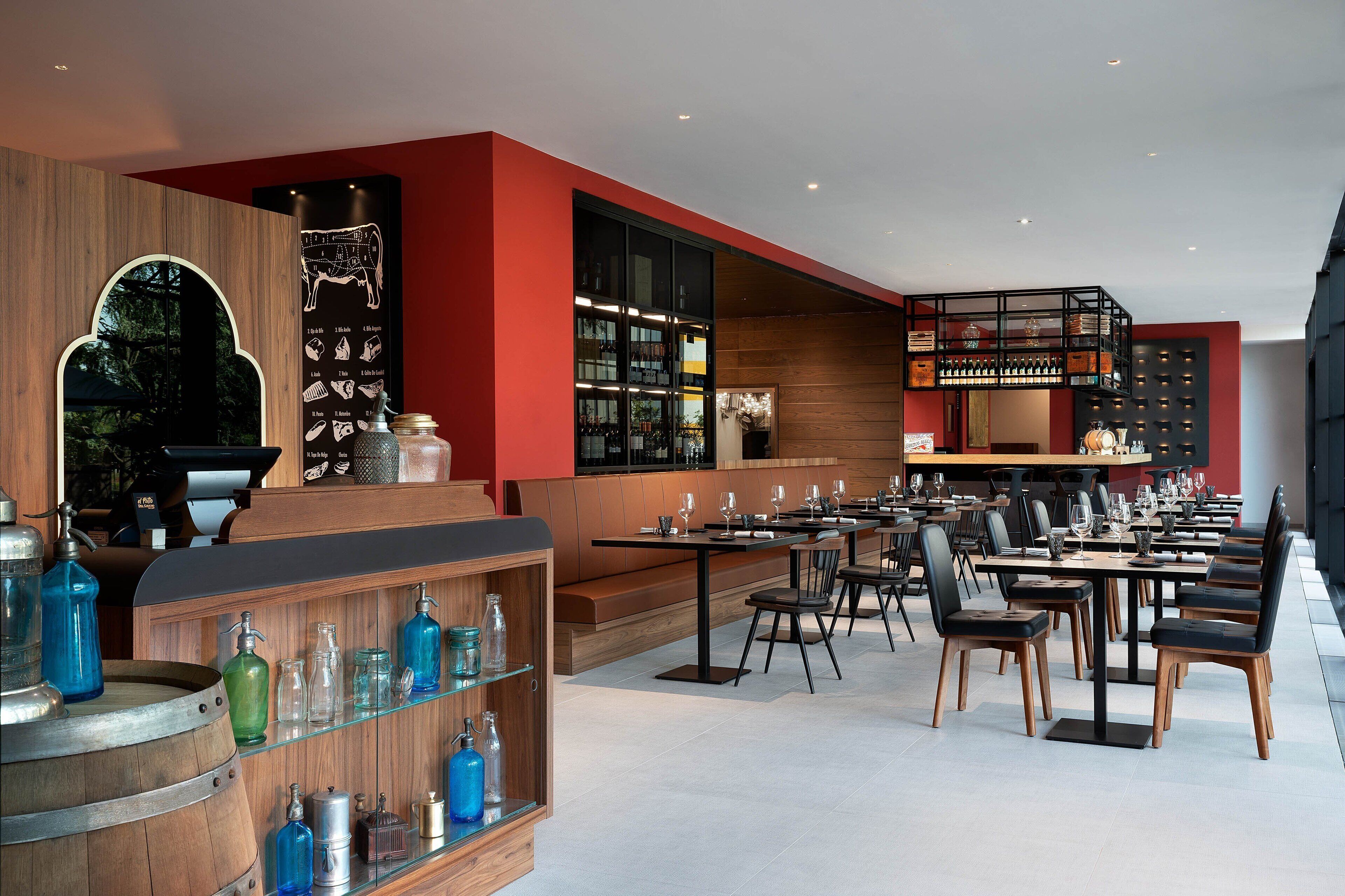 A modern restaurant with wooden accents, a bar area, and a seating arrangement for guests.