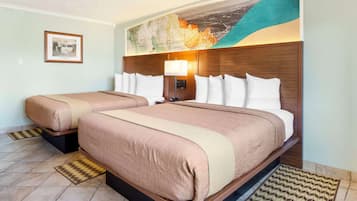 Habitación de hotel con dos camas, un mural de un mapa grande, un cuadro enmarcado en la pared y un cabecero moderno.