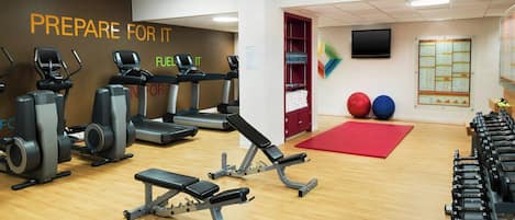 A gym with treadmills, weight machines, and exercise balls.