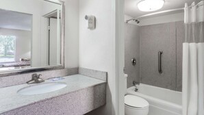 Ein Badezimmer mit Waschbecken, Spiegel, Dusche und Toilette.