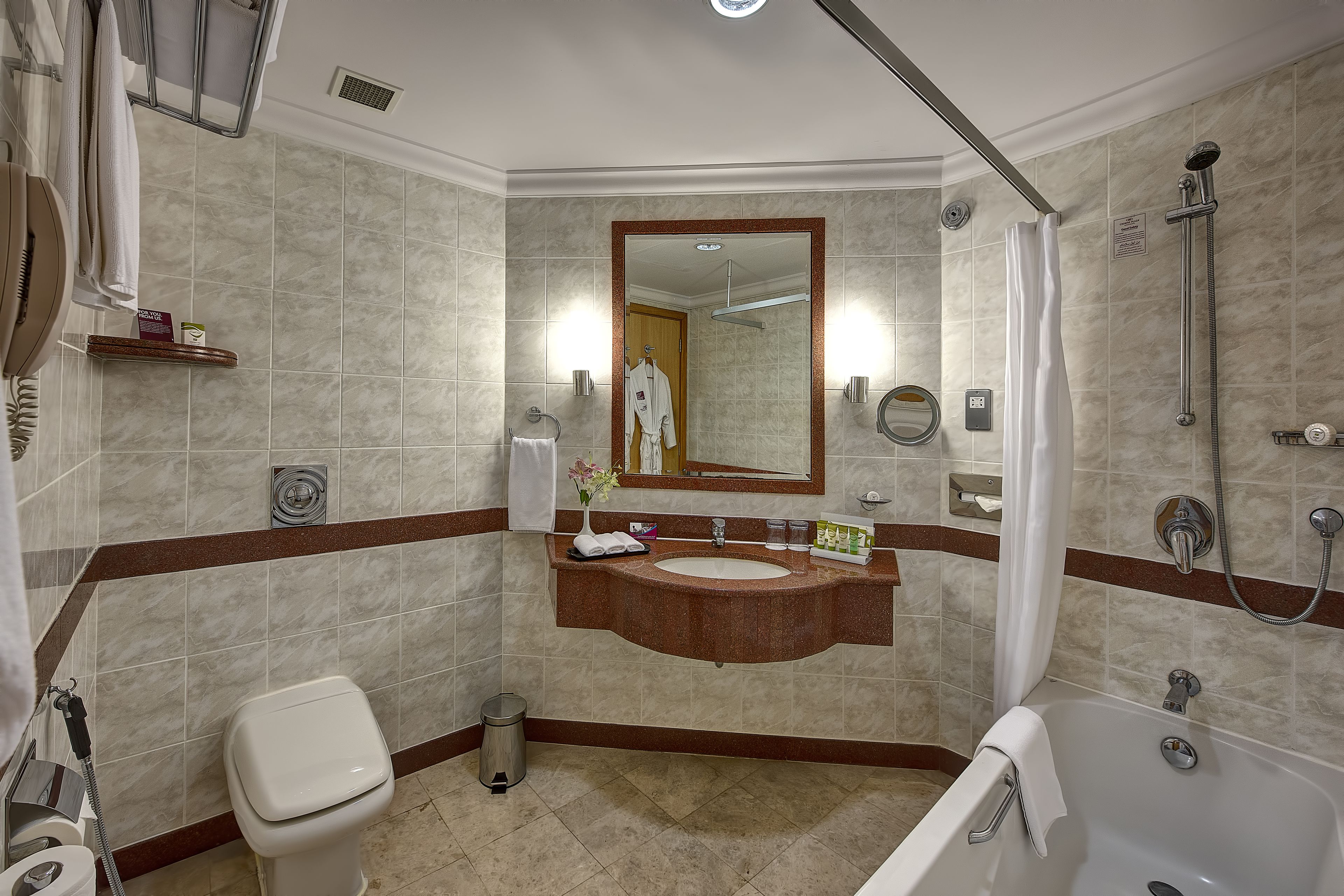 A bathroom with a toilet, sink, mirror, shower, and bathtub.