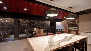 A modern kitchen with a marble countertop, red ceiling, and pendant lighting. - DoubleTree by Hilton St. Louis Airport (St. Louis)