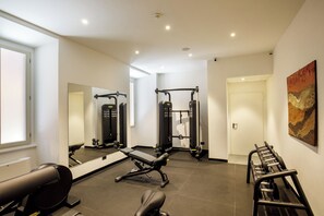 A modern gym with exercise equipment, a bench, and a mirror. - Hotel Nord Nuova Roma (Rome)