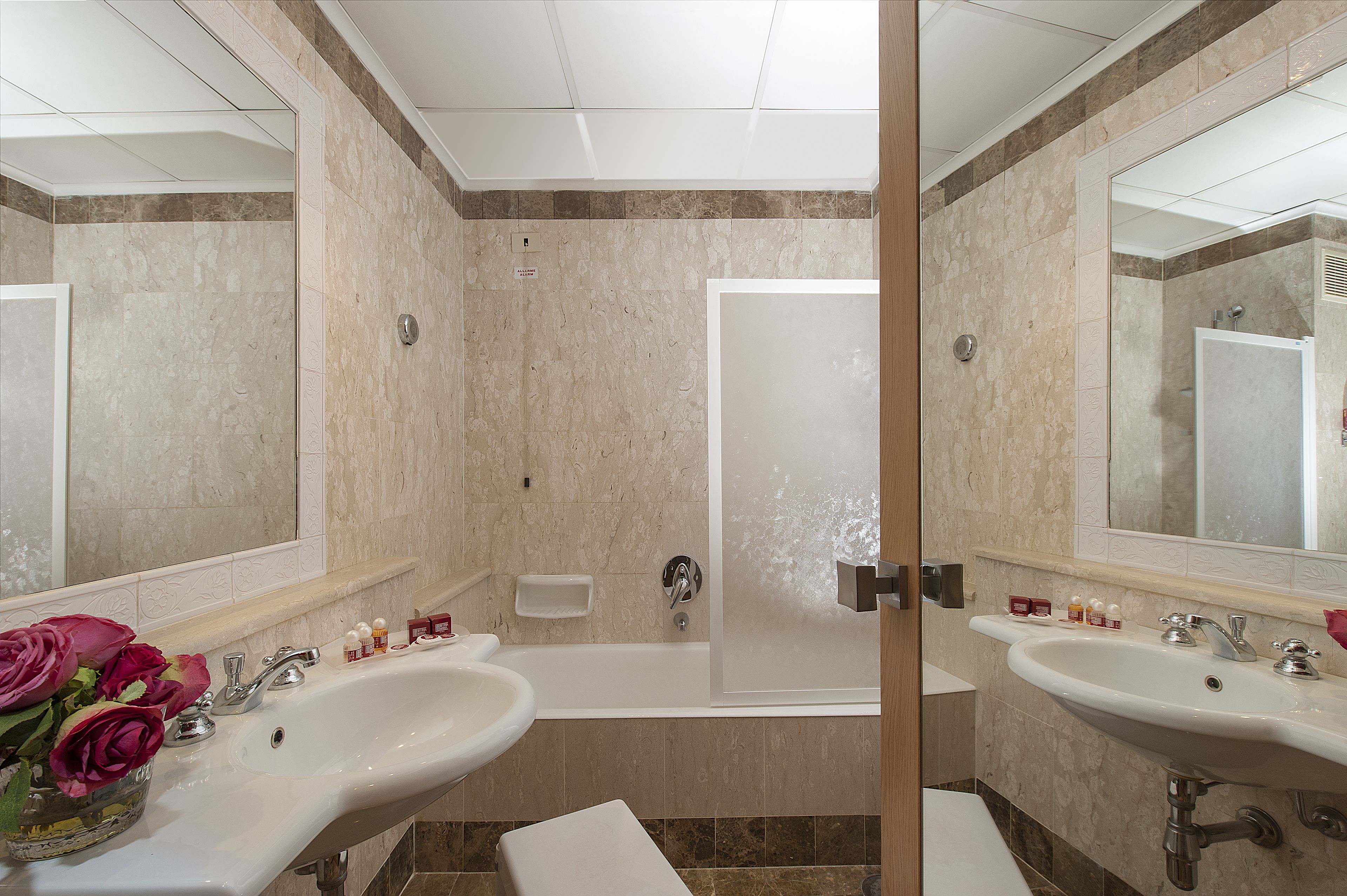 A modern bathroom with two sinks, a bathtub, and a shower.