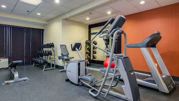 A gym with treadmills, an elliptical, and free weights.