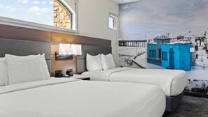 A hotel room with two beds, a stone wall, a mural of a pier, and a window. - La Quinta Inn & Suites by Wyndham Santa Cruz (Santa Cruz)