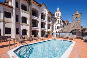 Una piscina al aire libre, sillones reclinables de piscina