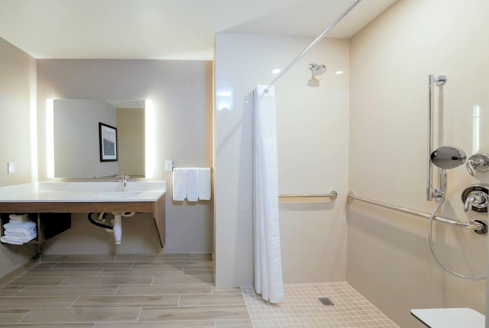 Un baño moderno con ducha, lavabo y espejo.