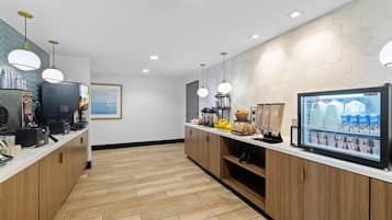 A modern kitchen with wooden cabinets, a coffee machine, a refrigerator, and a milk display.