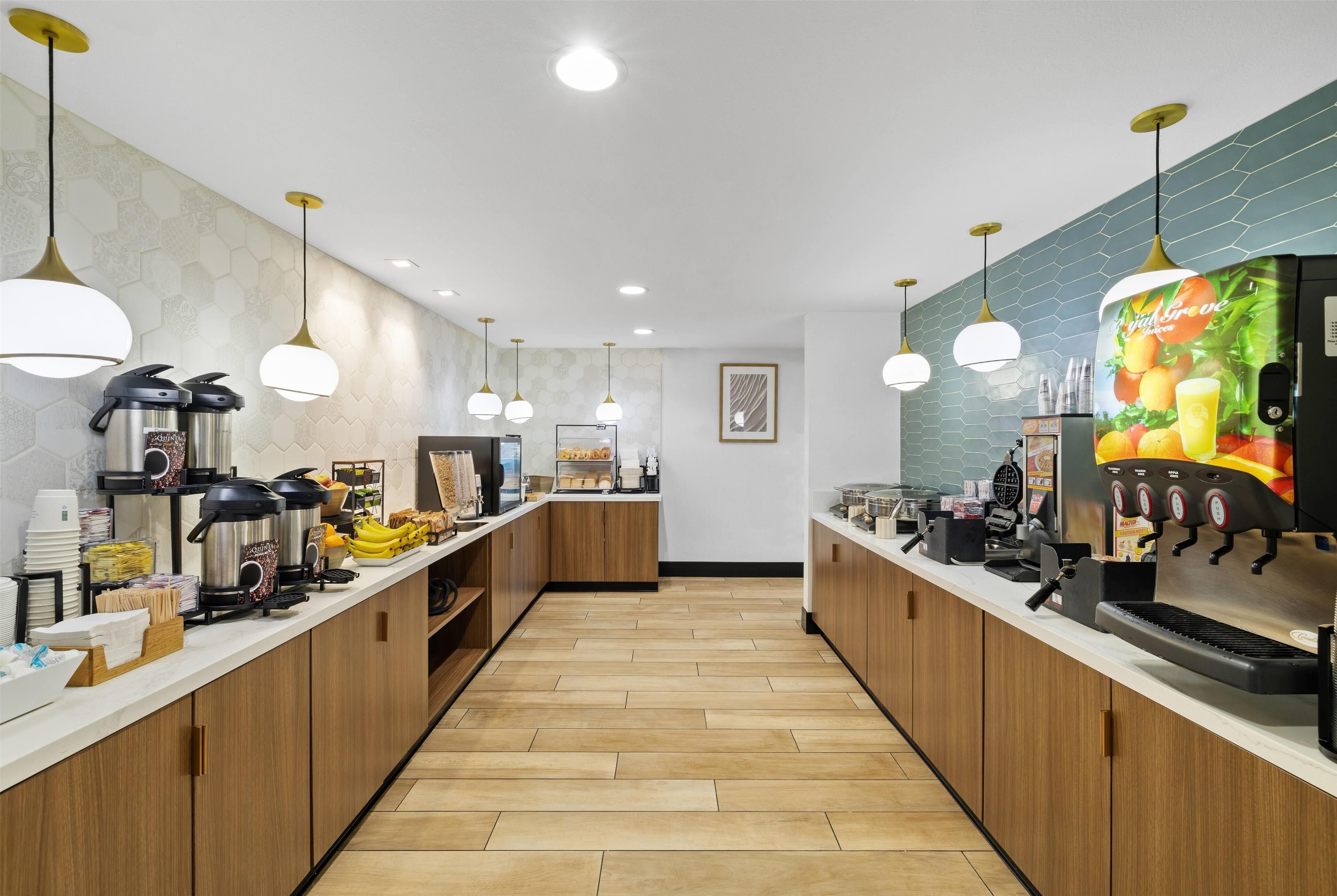 Een moderne keuken met roestvrijstalen apparatuur, houten keukenkastjes en een lang aanrecht.