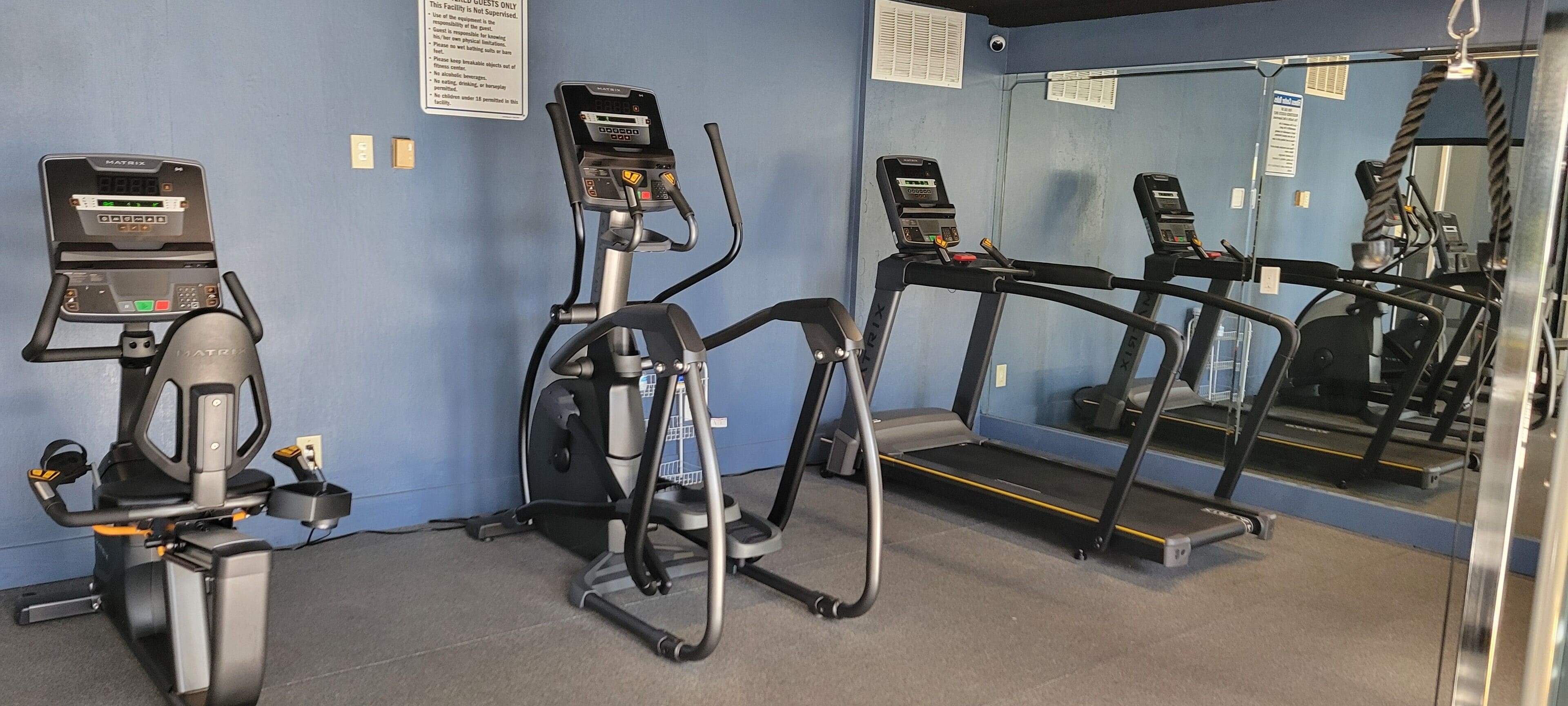 A gym with treadmills, an elliptical, and a stationary bike.