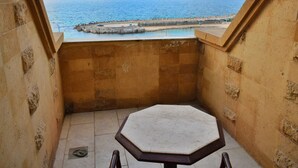A stone-walled balcony with a view of the sea and a pier. - Romance Alexandria Hotel (Alexandria)