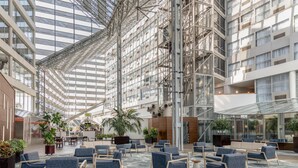 A spacious atrium with high ceilings, modern seating areas, and large windows allowing natural light.